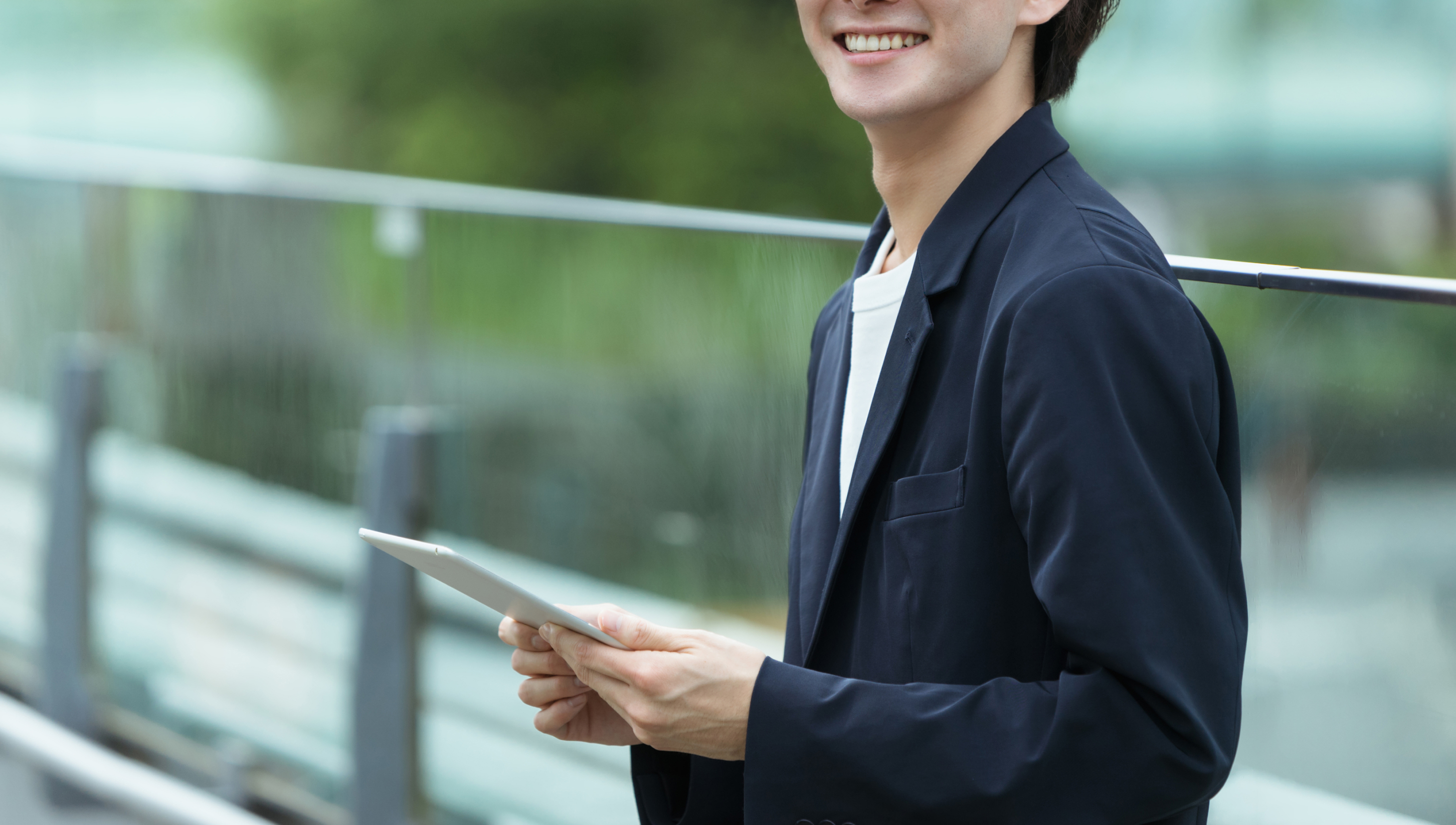 タブレットを持つスーツを着た男性